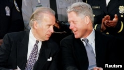 FILE - U.S. President Bill Clinton talks with Senator Joseph Biden at a meeting with law enforcement officers at the Alexandria, Virginia, Jan. 14, 1999.