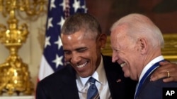 President Barack Obama laughs with Vice President Joe Biden during a ceremony in the State Dining Room of the White House in Washington, Jan. 12, 2017.