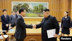 Lãnh tụ Triều Tiên Kim Jong Un (phải) gặp đặc sứ Hàn Quốc Chung Eui-yong.