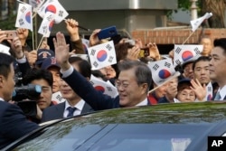 Tổng thống Hàn Quốc Moon Jae-in vẫy chào người dân tụ tập gần Dinh Ngói Xanh (phủ tổng thống) trước khi lên đường đến dự hội nghị thượng đỉnh liên Triều, Seoul, Hàn Quốc, ngày 27 tháng 4, 2018.