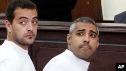 Phóng viên Mohamed Fahmy của hãng thông tấn Al-Jazeera (phải) và đồng nghiệp Baher Mohame tại phiên tòa ở Cairo.