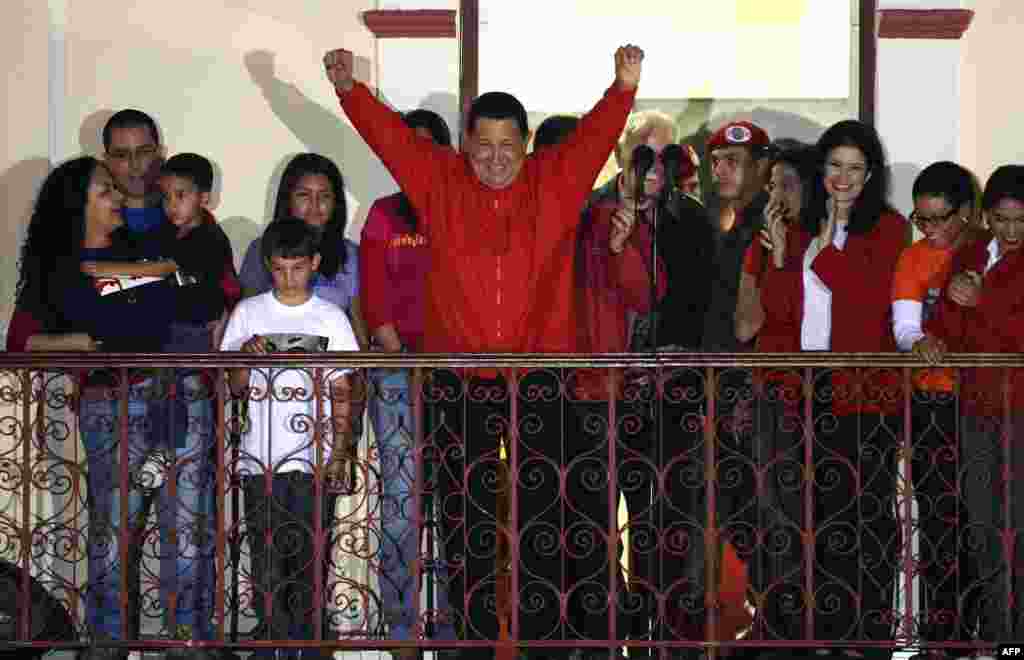 &Ocirc;ng Hugo Chavez l&agrave;m dấu hiệu chiến thắng khi ph&aacute;t biểu trước c&aacute;c ủng hộ vi&ecirc;n sau khi c&oacute; tin &ocirc;ng t&aacute;i đắc cử tổng thống ở Caracas.