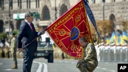 Tổng thống Ukraine Petro Poroshenko trao quốc kỳ cho một đơn vị quân sự trước cuộc diễu hành kỷ niệm ngày Quốc khánh của Ukraina ở thủ đô Kiev.