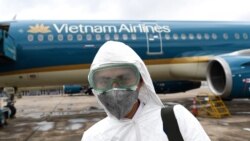 Tư liệu: Ảnh chụp ngày 3/3/2020 nhân viên chuẩn bị khử trùng một chiếc máy bay của Vietnam Airlines ở sân bay Nội Bài, Hà Nội. AFP