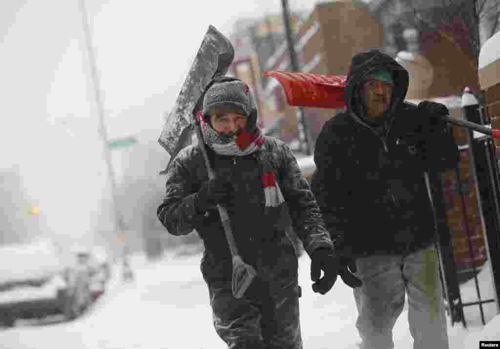 Hai người đàn ông vác xẻng đi bộ trên đường phố ở Detroit, Michigan, ngày 2/1/2014.