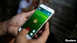 Một người đàn ông đang chơi Pokemon Go tại Hồ Hoàn Kiếm, Hà Nội, Việt Nam, ngày 18/8/2016. 