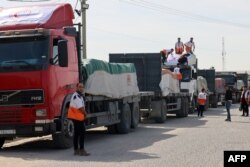 Yardım kamyonları Gazze'ye girdikten sonra malzemeleri boşaltıyor