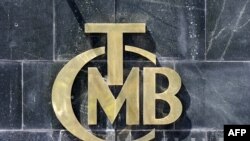 A picture taken on Aug. 14, 2018 shows the logo of Turkey's Central Bank (TCMB) at the entrance of the bank's headquarters in Ankara, Turkey