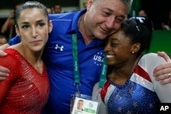 Vận động viên Simone Biles (phải) và bạn thân, vận động viên Aly Raisman, và đội trưởng Mihai Brestyan sau khi giành huy chương vàng và bạc ở nội dung thi đấu đơn nữ thể dục dụng cụ tại Thế vận hội Mùa hè 2016 ở Brazil, ngày 11 tháng 8 năm 2016.