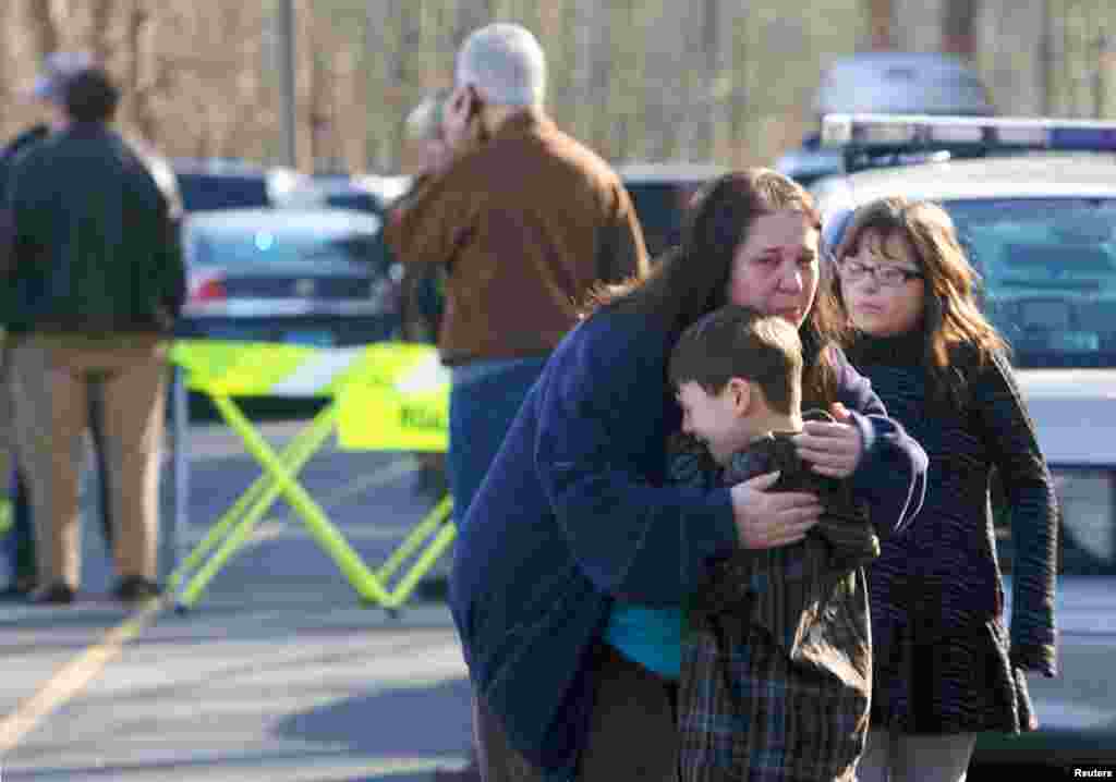 Một cậu b&eacute; được an ủi b&ecirc;n ngo&agrave;i trường tiểu học Sandy Hook, nơi xảy ra vụ nổ s&uacute;ng.