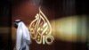 A Qatari employee of Al Jazeera Arabic language TV news channel passes by the logo of Al Jazeera in Doha, Qatar, Wednesday Nov. 1, 2006. The English language offshoot of Qatar based pan-Arab television news channel Al Jazeera said on Tuesday it will sta