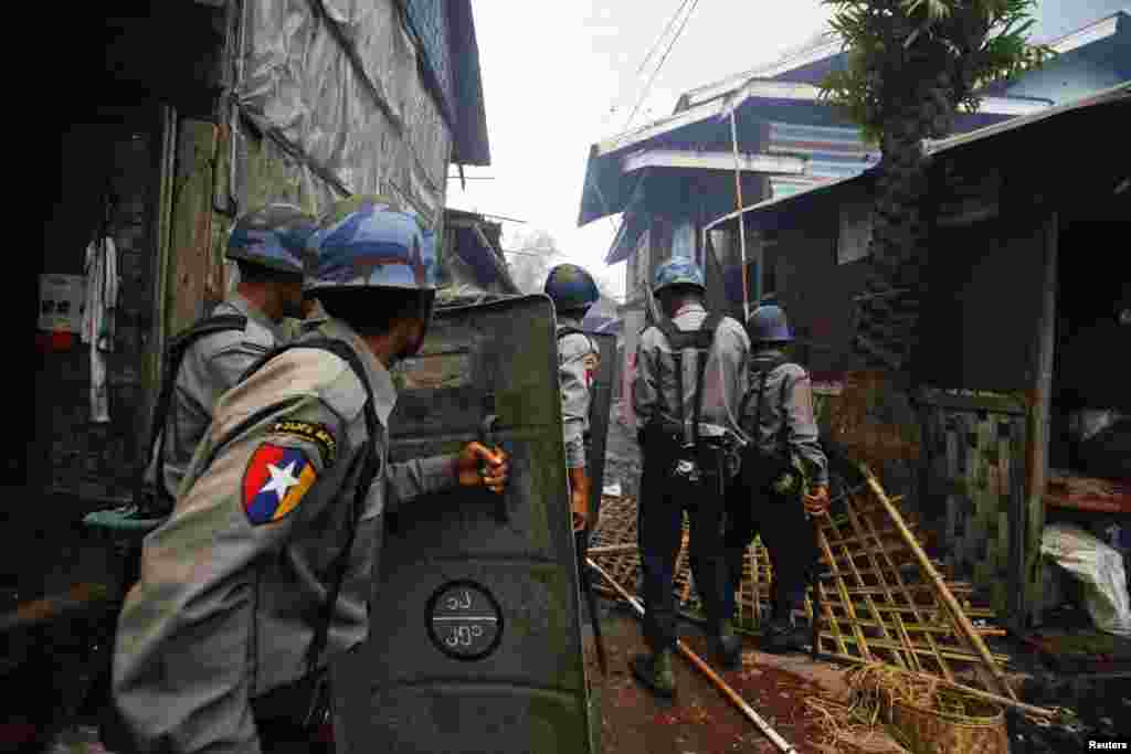 Cảnh s&aacute;t tiến đến những ng&ocirc;i nh&agrave; bị ch&aacute;y trong vụ xung đột tại Sittwe, 10/6/2012.