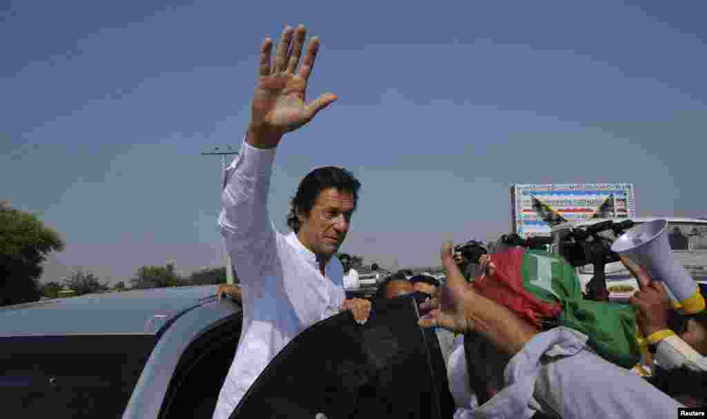 عمران خان ہاتھ ہلا کر شرکاء کا جواب دے رہے ہیں