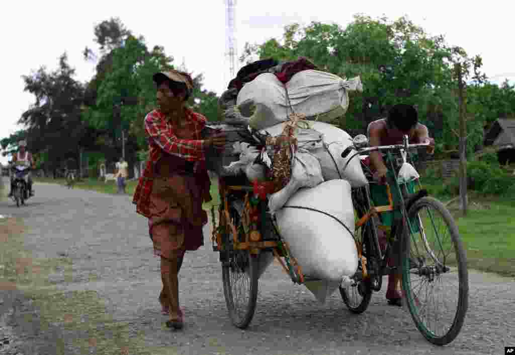 Cư d&acirc;n địa phương đẩy một xe ba b&aacute;nh chất đầy vật dụng tại Sittwe, nơi bạo động gi&aacute;o ph&aacute;i ảnh hưởng đến d&acirc;n ch&uacute;ng địa phương, 11/6/2012.