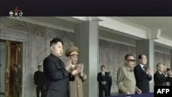 Lãnh tụ Bắc Triều Tiên Kim Jong-Il (đeo kính đen) và người con trai Kim Jong-un (trái) xem diễu binh tại quảng trường chính ở Bình Nhưỡng, 9/9/2011