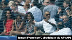 Chủ tịch Cuba Raul Castro (phải) ngồi cạnh Tổng thống Mỹ Barack Obama President Barack Obama, cùng đệ nhất phu nhân Michelle và hai người con gái của ông, xem trận đấu bóng chày giao hữu giữa đội Tampa Bay Rays của Mỹ và đội tuyển quốc gia Cuba, ở Havana, Cuba, ngày 22 tháng 3, 2016.