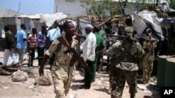 Cảnh sát và binh sĩ Somalia tại hiện trường vụ nổ bom tự sát ở Mogadishu, ngày 14/3/2012