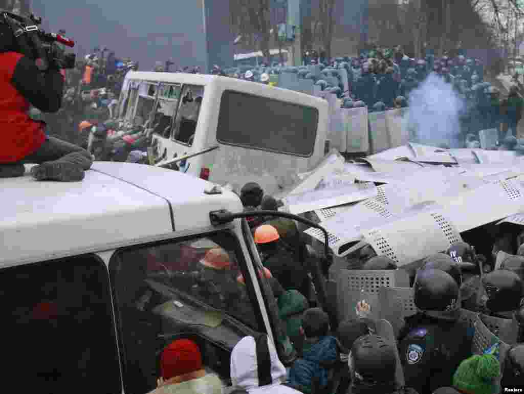 Người biểu tình Ukraina tấn công một chiếc xe cảnh sát trong cuộc biểu tình ở Kyiv, 19/1/14