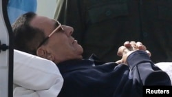 Cựu Tổng thống Ai Cập Hosni Mubarak nằm trên cáng trong khi được đưa đến toà án ở Cairo, 27/9/2014.