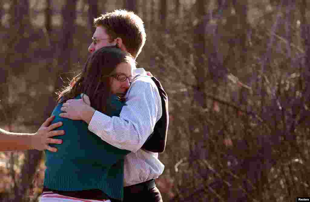 Family members embrace each other outside Sandy Hook Elementary School.