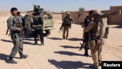 FILE - Afghan Special Forces and policemen prepare for battle with the Taliban on the outskirts of Lashkar Gah, capital of Helmand, Afghanistan, Oct. 10, 2016.