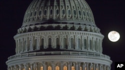 The moon rises behind the U.S. Capitol Dome as Congress works into late evening to resolve fiscal cliff issue 