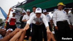 Lãnh tụ đối lập Campuchia Sam Rainsy chào những người ủng hộ ông ở tỉnh Kampong Speu, ngày 20/7/2013.