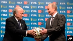 Chủ tịch Sepp Blatter của FIFA trao quả bóng cho Tổng thống Nga Vladimir Putin sau trận chung kết World Cup 2014 tại Brazil.