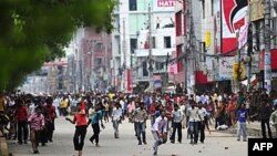 Công nhân dệt may Bangladesh ném các đồ vật vào cảnh sát trong cuộc đụng độ ở Dhaka, ngày 30 tháng 6 2010