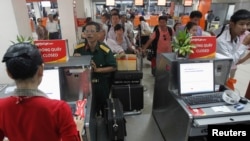 Hành khách xếp hàng làm thủ tục lên máy bay tại quầy của Hãng hàng không giá rẻ Vietjet Air ở sân bay Tân Sơn Nhất, ngày 20/10/2013.