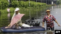 Cư dân Thái Lan lội qua 1 khu vực bị ngập lụt tại huyện Don Muang ở Bangkok, Thái Lan, 23/10/2011