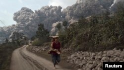 Dân làng tháo chạy khi núi lửa Sinabung phun trào ở làng Sigarang-Garang thuộc huyện Karo, tỉnh Bắc Sumatra của Indonesia, ngày 1 tháng 2, 2014.