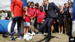 Ông Macron đá bóng khi tới thăm một dự án về thiện nguyện ở phía đông Paris hôm 3/8/2017.