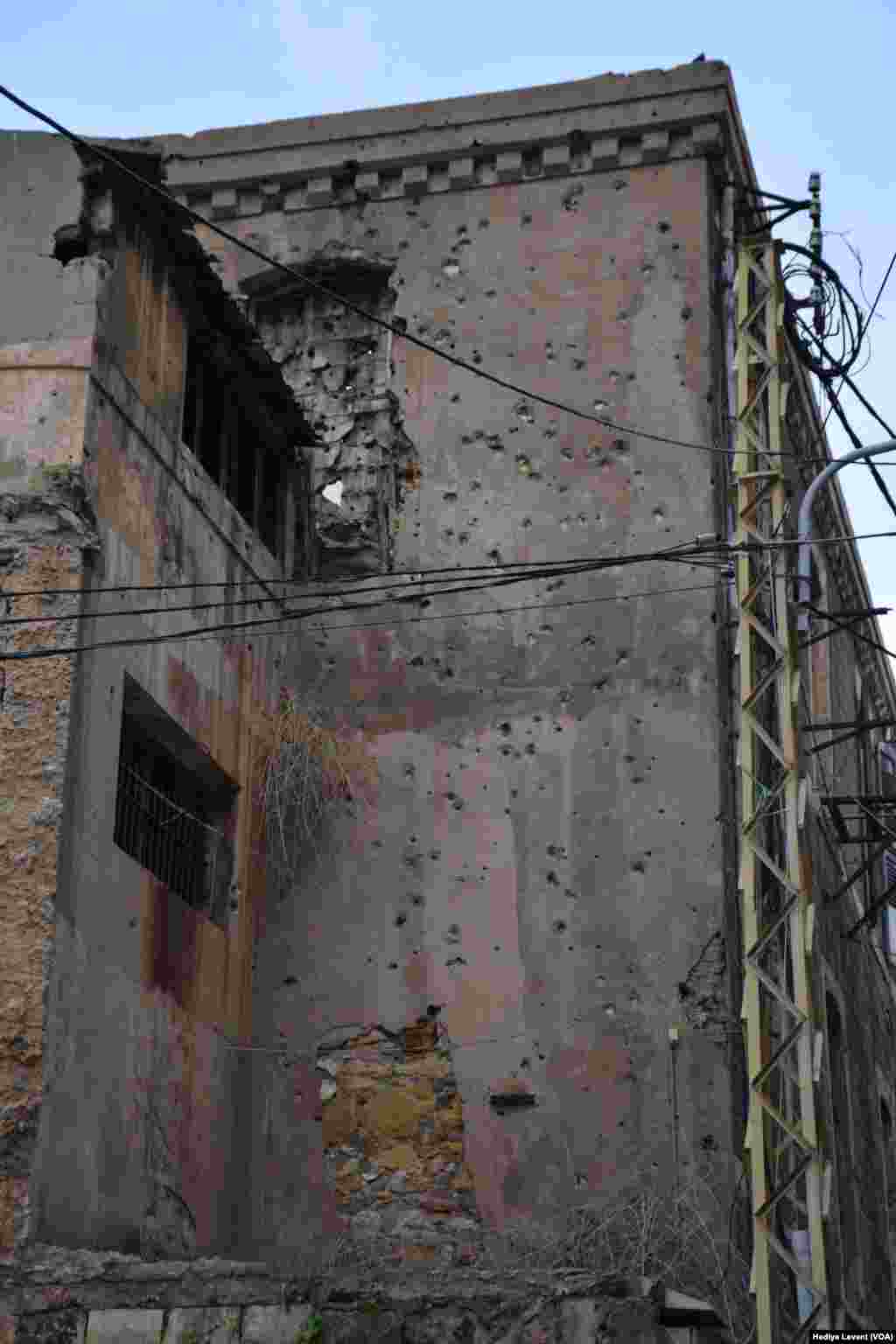 Duvarlarında kurşun delikleri olan, bakımsız kaldığı dış cephesinden anlaşılan eski tip yapılar hızla yükselen modern binaların ve gökdelenlerin gölgesinde kalıyor. &nbsp;