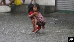 Hai em bé Philippines đi qua vùng lụt lội ở ngoại ô Mandaluyong nằm ở phía đông Manila, Philippines, vì bão Nepartak hôm 8/7.