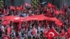 Turkish citizens wave their national flags as they protest against the military coup outside Turkey's parliament near the Turkish military headquarters in Ankara, Turkey, July 16, 2016. 