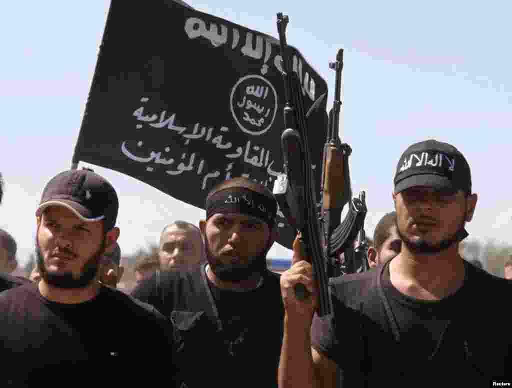 Islamist fighters carry their flag during the funeral of their fellow fighter Tareq Naser, who died during clashes near the village of Fafeen outside Aleppo, Syria, September 17, 2012. 