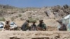 In this May 27, 2016, photo, Taliban fighters eat lunch in Shindand district of Herat province, Afghanistan.